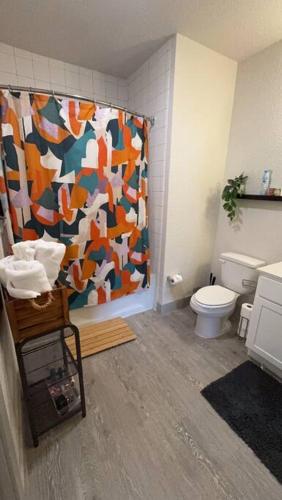 a bathroom with a shower curtain and a toilet at Beautiful Condo on Riverwalk King Suite w Free Parking Pet Friendly Centrally Located on the Riverwalk in San Antonio