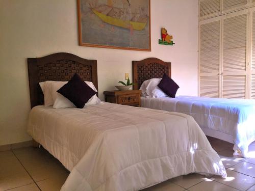 - une chambre avec 2 lits et des draps blancs dans l'établissement Condo Selva Alta, à Puerto Vallarta