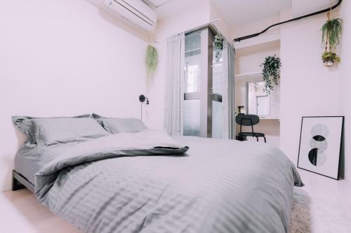 a white bedroom with a bed and a window at Minimalist Loft Namba Compact Studio with a 24-hour Gym MA401 in Osaka
