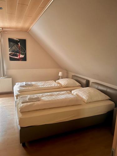 two twin beds in a room with a attic at Hotel Restaurant Parthenon in Otterbach