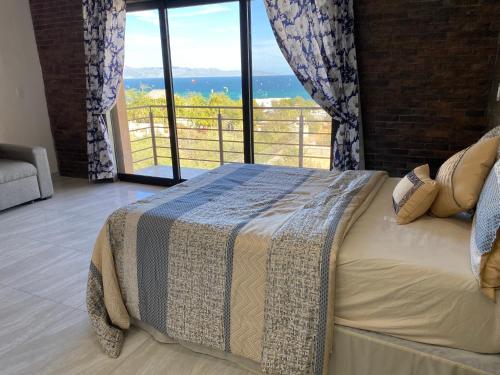 a bedroom with a bed with a view of the ocean at STELLA MARIS Boutique Hotel in El Sargento