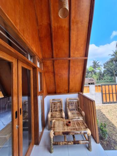 a room with a balcony with wicker beds on it at D' Rinjani View Bungalow in Masbagik
