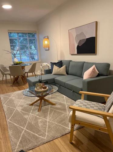 a living room with a blue couch and a table at Stylish Comfort on the Park in Melbourne