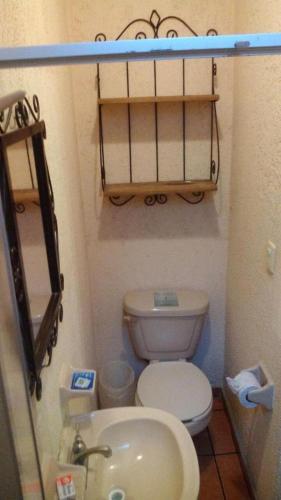 a small bathroom with a toilet and a sink at Hotel Casa Galena in Morelia