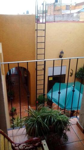 a balcony with a ladder next to a building at Hotel Casa Galena in Morelia