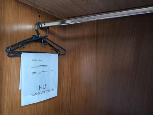 a sign hanging on a door with a hanger at La Floresta de Cite Hotel in Cite