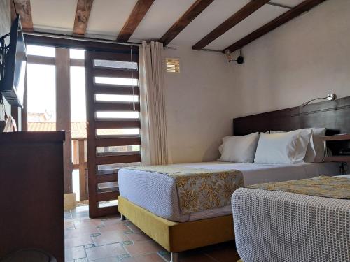 a bedroom with a bed and a window and a bed sidx sidx sidx at La Floresta de Cite Hotel in Cite