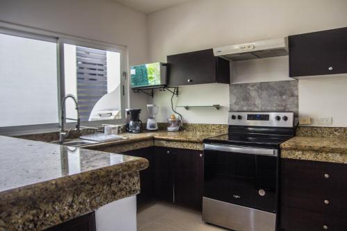 a kitchen with a stove and a sink at Creuza de Mä in Playa del Carmen