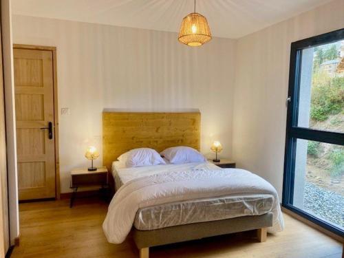 une chambre avec un lit avec deux lampes et une fenêtre dans l'établissement Chalet luxueux à Font Romeu avec garage, 4 chambres, proche télécabines - FR-1-703-193, à Font-Romeu-Odeillo-Via