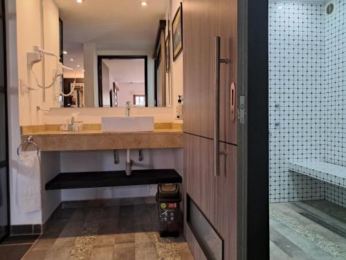 a bathroom with a sink and a mirror at La Floresta de Cite Hotel in Cite