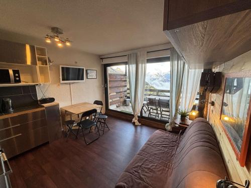 une chambre avec un lit, une table et une fenêtre dans l'établissement Studio cabine 4 couchages au pied des pistes, proche commerces - Auris en Oisans - FR-1-297-343, à Auris