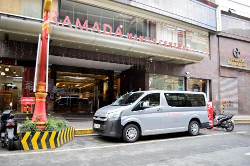 a white van parked in front of a store at Ramada by Wyndham Manila Central in Manila