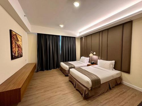 a hotel room with two beds and a window at Swiss-Garden Hotel Melaka in Melaka