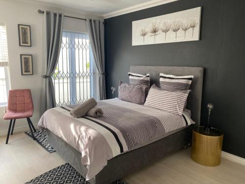 a bedroom with a bed with a teddy bear on it at Bed and Breakfast Villa Livadia in Cape Town