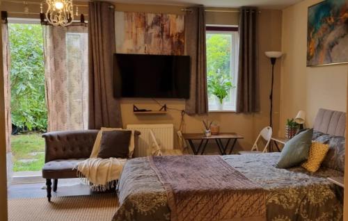 a bedroom with a bed and a couch and a tv at Spacious Studio with Free Parking West Molesey KT8 in West Molesey