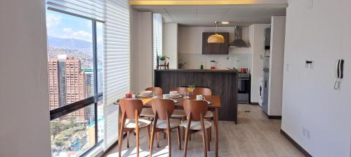 jadalnia ze stołem i krzesłami oraz oknem w obiekcie Penthouse titanium mac w mieście La Paz