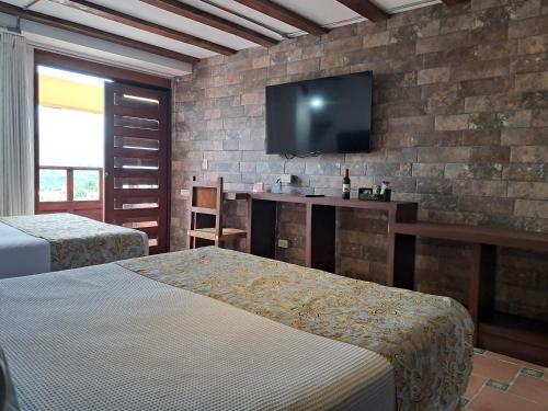 a hotel room with two beds and a flat screen tv at La Floresta de Cite Hotel in Cite