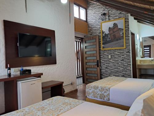 a hotel room with two beds and a flat screen tv at La Floresta de Cite Hotel in Cite