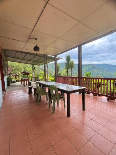 a patio with tables and chairs on a balcony at SU Valley Lodge in Bundu Tunan