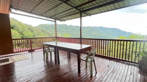 a wooden deck with a table and chairs on a balcony at SU Valley Lodge in Bundu Tunan