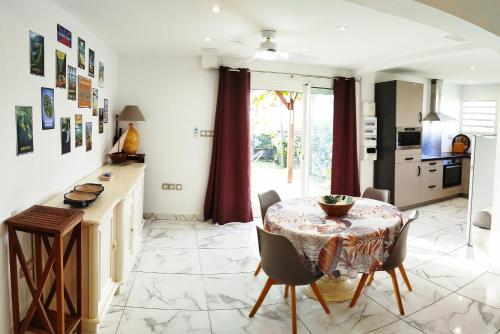 a kitchen and dining room with a table and chairs at Maison Les Cocotiers de Plaiz'Anse in Petite Île