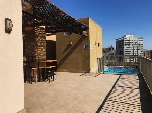 d'un toit-terrasse avec une table, des chaises et une piscine. dans l'établissement Bello y acogedor dpto cerca metro Baquedano 1303, à Santiago