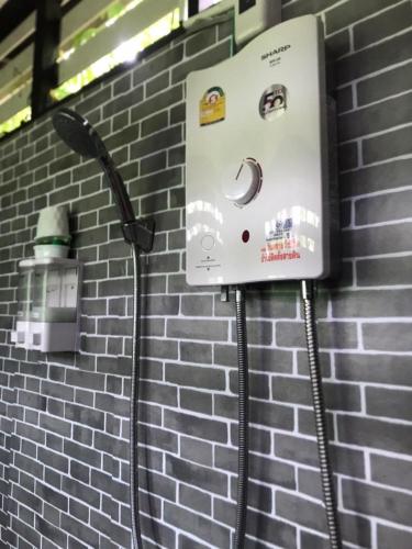 a pay phone on a brick wall at บ้านชมจันทร์ บ้านสวนสราญชล in Ban Nong Bo