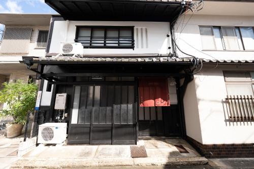 a white house with black doors and windows at JPRESERVE Bishamoncho in Kyoto