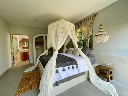 Schlafzimmer mit einem Himmelbett und Moskitonetzen in der Unterkunft Casa Mystic Boutique villa in Gili Air
