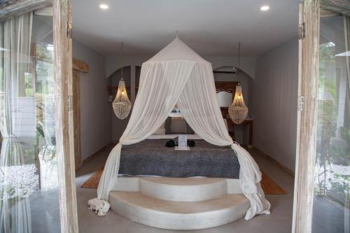 ein Schlafzimmer mit einem Himmelbett in der Unterkunft Casa Mystic Boutique villa in Gili Air