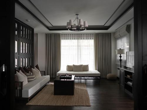 a living room with a couch and a window at Burirattana Hotel-An Adults Only Hotel in Chiang Mai