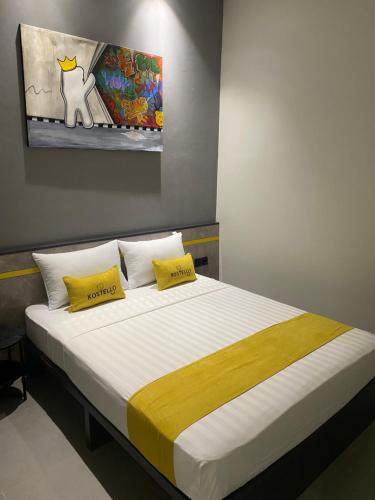 a bed with two yellow pillows on top of it at Kostello Rajawali in Palembang