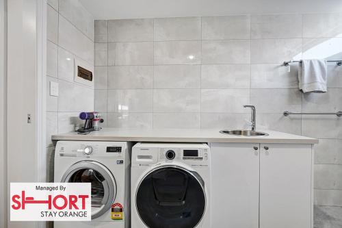 a kitchen with a washing machine and a sink at Conservatorium Villa 2 in Orange