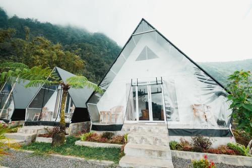 a small white house with a triangular roof at Popitan Garden Campground & Glamping Bedugul in Bedugul