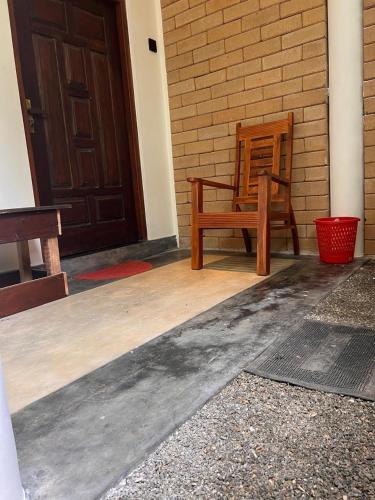 a porch with a wooden chair and a door at Siri Villa Habaraduwa in Habaraduwa