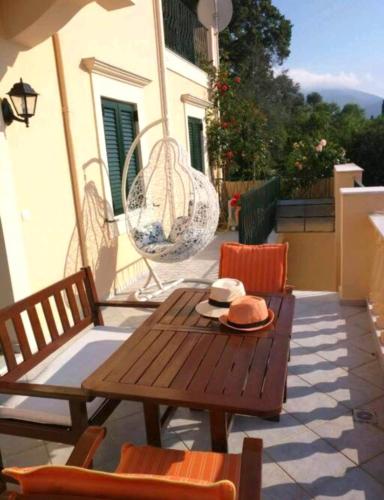 a patio with a table and chairs and a swing at Estia sea view in Sami