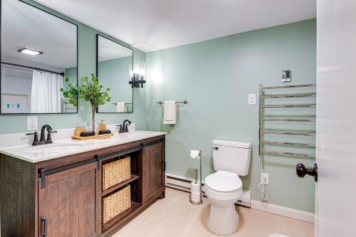 a bathroom with a toilet and a sink and a mirror at Game Room and Fire Pit Chic Pocono Pines Home! in Pocono Pines
