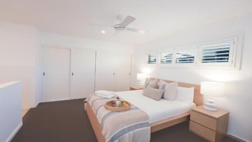 ジェロアにあるSeven Mile Heavenのベッドと窓のある白い寝室