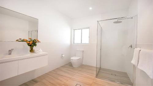 ジェロアにあるSeven Mile Heavenの白いバスルーム(トイレ、ガラス張りのシャワー付)