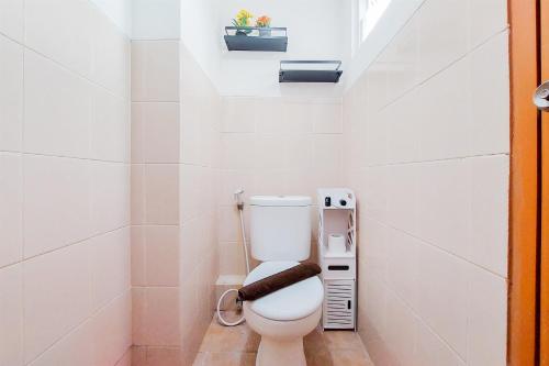 a white bathroom with a toilet with a phone at Comfort Stay 2BR at Loftvilles City Apartment By Travelio in Tangerang