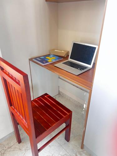 a laptop computer sitting on a desk with a chair at SAHARHOMEstay O3 in Mysore
