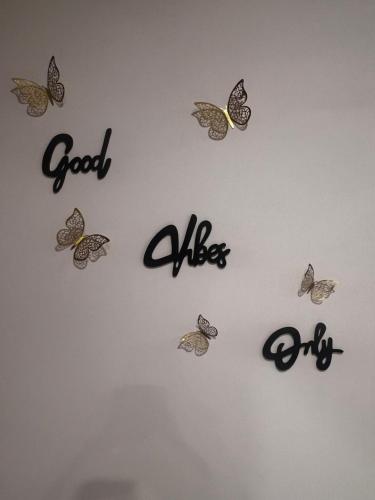a wall with butterflies and the words good vibes at SAHARHOMEstay O3 in Mysore