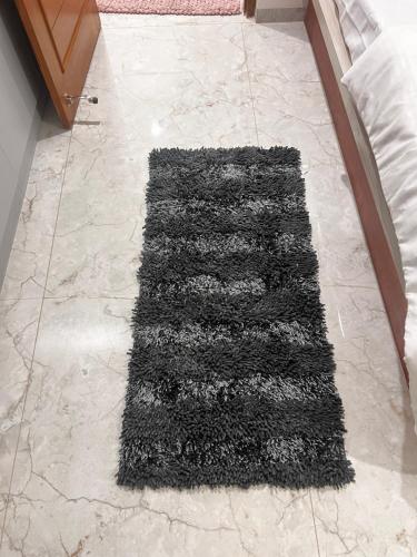 a black rug on the floor in a room at SAHARHOMEstay O3 in Mysore
