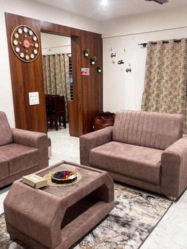 a living room with two couches and a table at SAHARHOMEstay O3 in Mysore