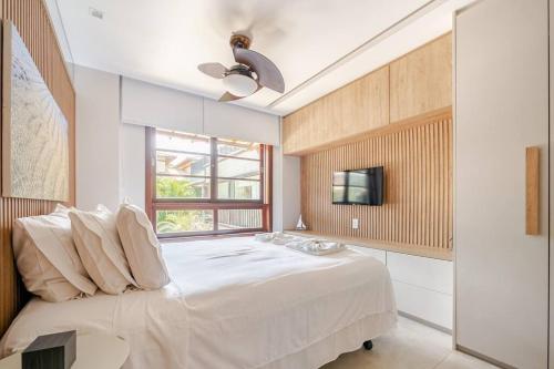 a bedroom with a large bed and a window at PRAIA DO FORTE CONDOMINIO KAUAI in Praia do Forte