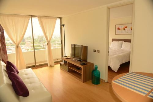 a living room with a bed and a television at Chilean Suites Providencia II in Santiago