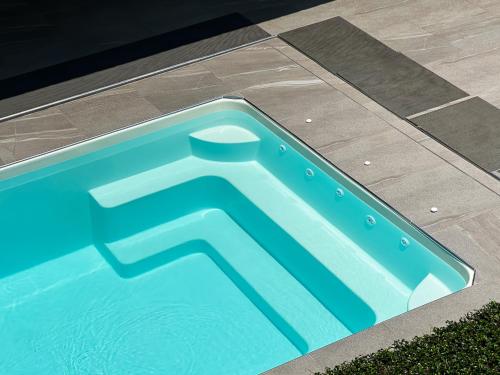 a blue swimming pool with a geometric design on the ground at Tachang Airport Hotel in Hat Yai