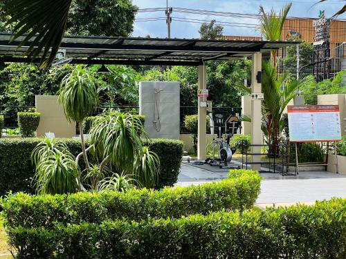 a pavilion with trees and bushes in a park at Tachang Airport Hotel in Hat Yai