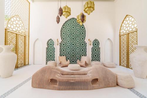 a room with a bed and chairs in front of a mosque at Sana Tulum Beachfront Boutique Hotel in Tulum
