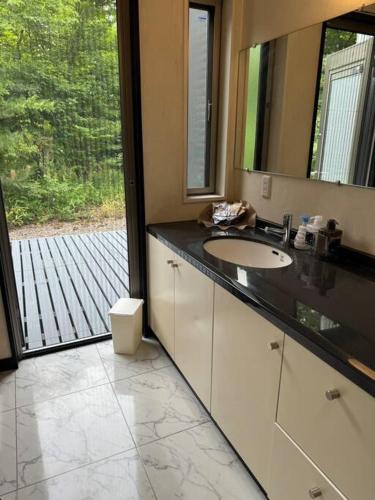 a bathroom with a sink and a large window at 那須小結 Fabulous House 一棟貸BBQ in Nasu